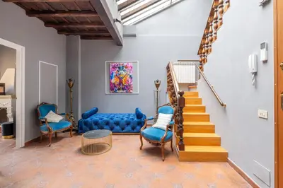 a living room with a blue couch and stairs at maison pelliccia Terrace in Rome