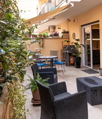 a patio with wicker chairs and tables and plants at Ædrian's Loft. Boutique apartment with private terrace in the center of Rome in Rome