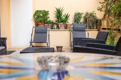 a table and chairs in a patio with plants at Ædrian's Loft. Boutique apartment with private terrace in the center of Rome in Rome