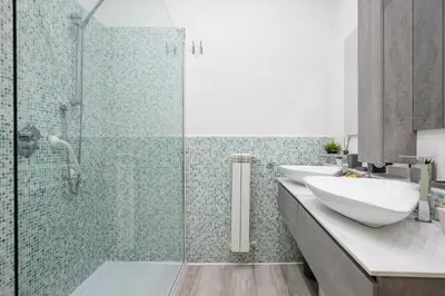a bathroom with two sinks and a glass shower at Appartamento via di Torre Argentina (Navona) in Rome