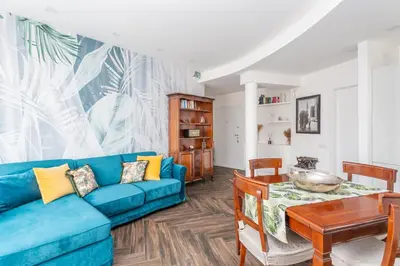 a bedroom with a white bed with a tropical painting on the wall at Gregory 7House Vaticano in Rome
