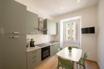a kitchen with a white table and a table and chairs at Casa M.O.R.E. in Rome