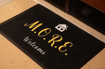 a sign for a new restaurant on a table at Casa M.O.R.E. in Rome