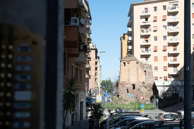 a group of cars parked in a street between buildings at Casa M.O.R.E. in Rome