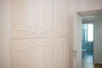 a white closet with white cabinets in a room at Casa M.O.R.E. in Rome