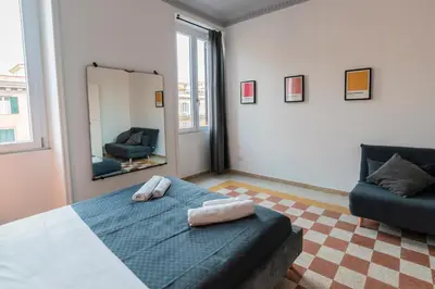 a bedroom with a bed and a mirror and a couch at Vintage Giuliana Apartment in Rome