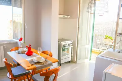 a kitchen with a table and chairs and a kitchen with a window at FLOWER HOUSE in Rome