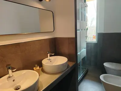 a bathroom with a sink and a mirror and a toilet at FLOWER HOUSE in Rome