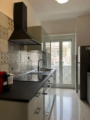 a kitchen with a black counter and a sink at A casa nostra - Musei Vaticani in Rome