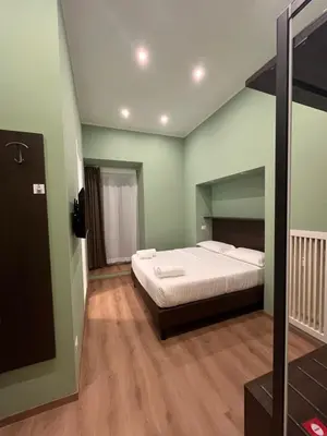 a bedroom with a bed in a room with green walls at Colosseum Deluxe in Rome