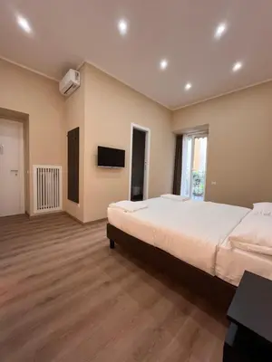 a large bedroom with a large bed and a flat screen tv at Colosseum Deluxe in Rome