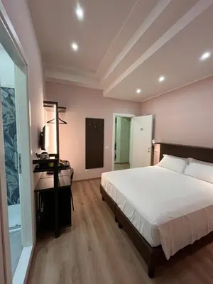 a bedroom with a large bed and a desk at Colosseum Deluxe in Rome