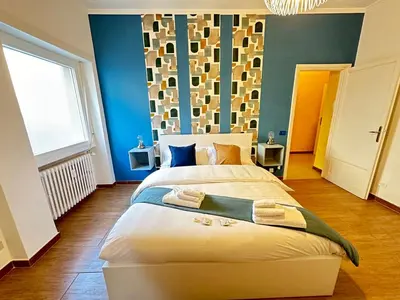 a bedroom with a large bed with blue walls at Il Giardino a Monte Sacro in Rome