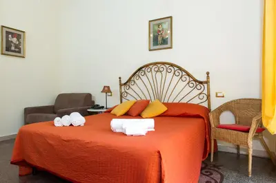 a bedroom with a large orange bed with towels on it at Boezio House in Rome