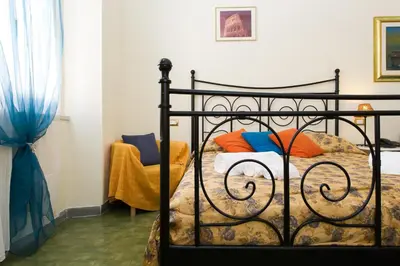 a black bed with colorful pillows in a bedroom at Boezio House in Rome