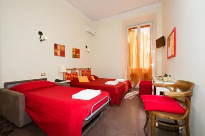 a bedroom with two beds and a table and chairs at Boezio House in Rome