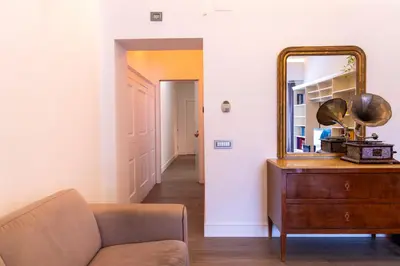 a living room with a couch and a mirror on a dresser at Regina Margherita Home in Rome