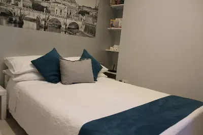 a bedroom with a bed with blue and white pillows at Argilla House 10 min a piedi dal Vaticano in Rome