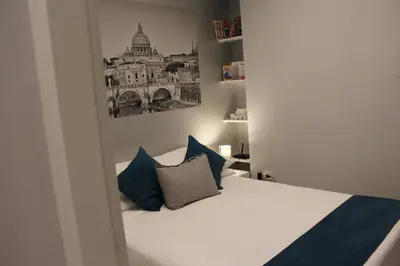 a small bedroom with a bed with blue pillows at Argilla House 10 min a piedi dal Vaticano in Rome