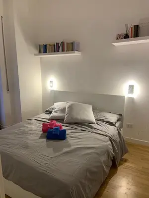 a bedroom with a bed with two bags on it at NINA'S HOUSE in Rome