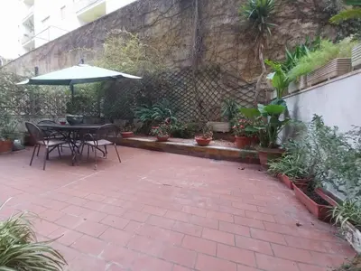 a patio with a table and an umbrella and plants at NINA'S HOUSE in Rome