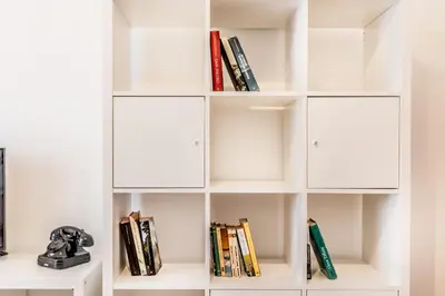 a white book shelf with books at Retro design flat near Vaticano in Rome
