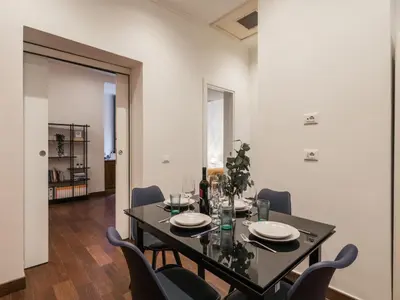 a dining room with a black table and chairs at The Best Rent -Cozy two bedroom apartment near Vatican City in Rome