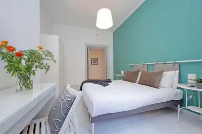 a bedroom with a bed and a vase of flowers at Casa Serafina in Prati district in Rome