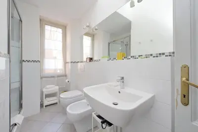 a white bathroom with a sink and a toilet at Casa Serafina in Prati district in Rome