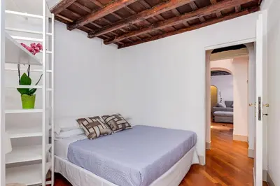 a white bedroom with a bed and a ladder at Che Eleganza! Irresistibile dimora, Campo de Fiori in Rome