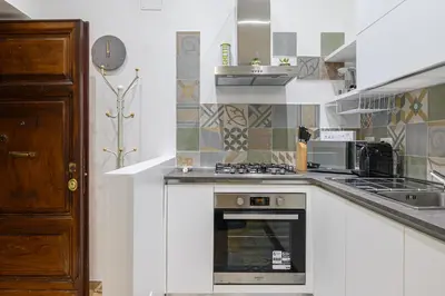 a kitchen with a stove and a microwave at Appartamento via Visconti in Rome