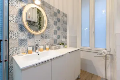 a bathroom with a white sink and a mirror at Appartamento via Visconti in Rome