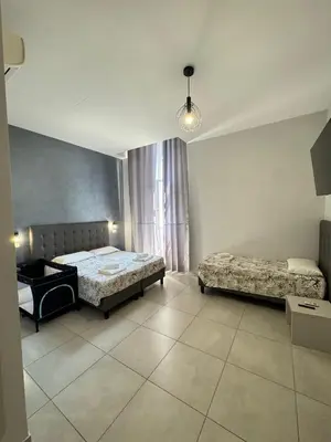 a bedroom with two beds and a table and a window at ANGI HOME in Rome