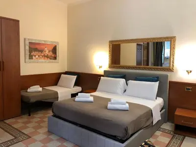 a hotel room with two beds and a mirror at A ROSMINI SUITES in Rome