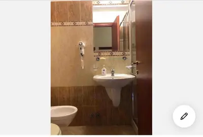 a bathroom with a sink and a toilet and a mirror at A ROSMINI SUITES in Rome