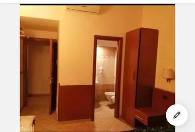a bathroom with a toilet and a wooden cabinet at A ROSMINI SUITES in Rome