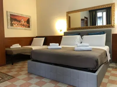 a bedroom with two beds and a mirror at A ROSMINI SUITES in Rome