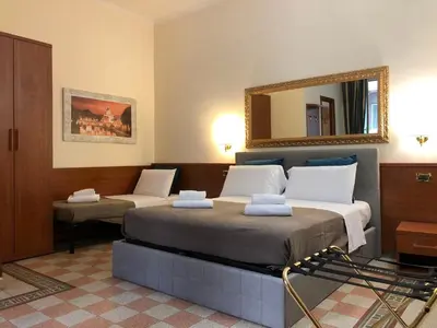 a bedroom with two beds and a mirror on the wall at A ROSMINI SUITES in Rome