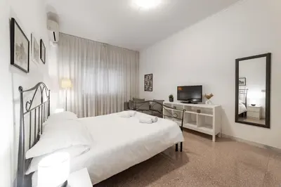 a white bedroom with a bed and a mirror at EV Vatican Apartment in Rome