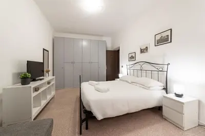 a white bedroom with a bed and a television at EV Vatican Apartment in Rome