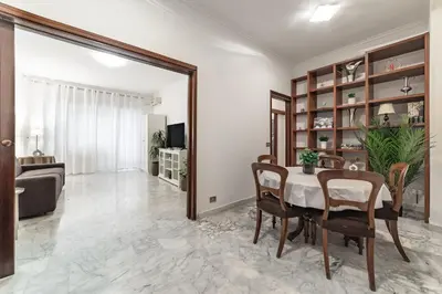 a dining room with a table and chairs and a mirror at EV Vatican Apartment in Rome