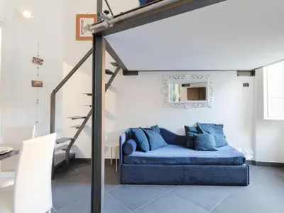 a blue couch in a living room with a staircase at Studio Le Belle Arti by Interhome in Rome
