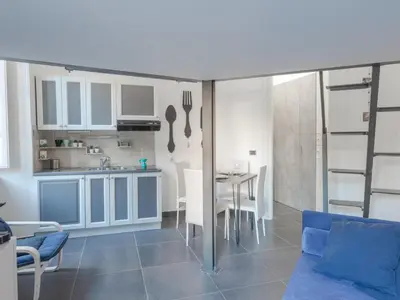 a kitchen and a living room with a couch and a table at Studio Le Belle Arti by Interhome in Rome