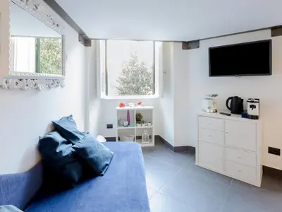 a living room with a blue couch and a tv at Studio Le Belle Arti by Interhome in Rome