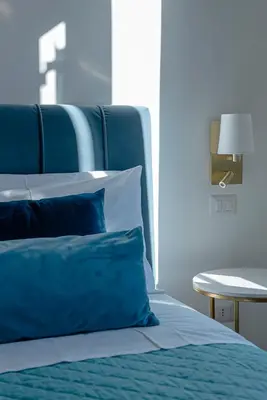 a bed with blue and white pillows and a table at Dolce casa al Vaticano in Rome