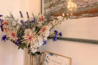 a vase of flowers on a wall with a picture at Dolce casa al Vaticano in Rome
