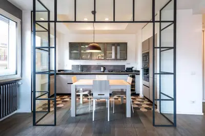 a kitchen with a dining room table and glass walls at Time 4 Rome in Rome