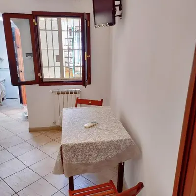 a table and chairs in a room with a window at Appartamento Eleonora in Rome
