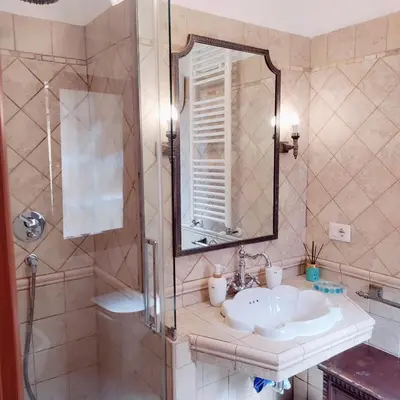 a bathroom with a sink and a shower with a mirror at Appartamento Eleonora in Rome