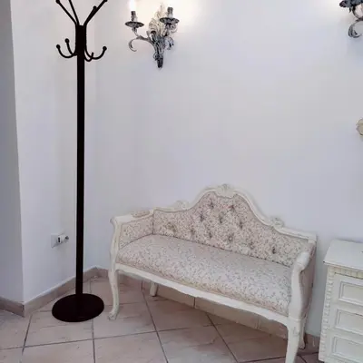 a white bench in a room with a lamp at Appartamento Eleonora in Rome